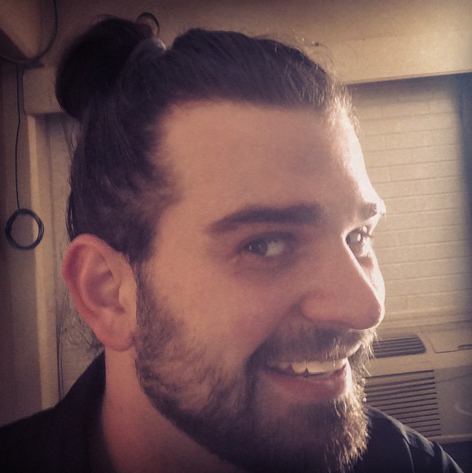 A-male-with-a-man-bun-hairstyle-and-the-classic-hipster-beard
